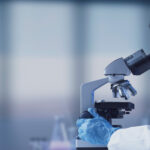 Researcher using a professional microscope Researcher using a professional microscope