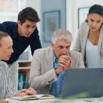Innovation im Unternehmen: KMU-Team mit Boss schauen angestrengt aufs Laptop Innovation im Unternehmen: KMU-Team mit Boss schauen angestrengt aufs Laptop